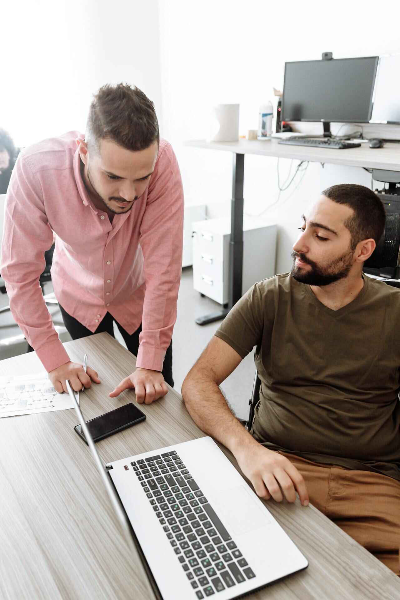 two coworkers looking at a laptop
